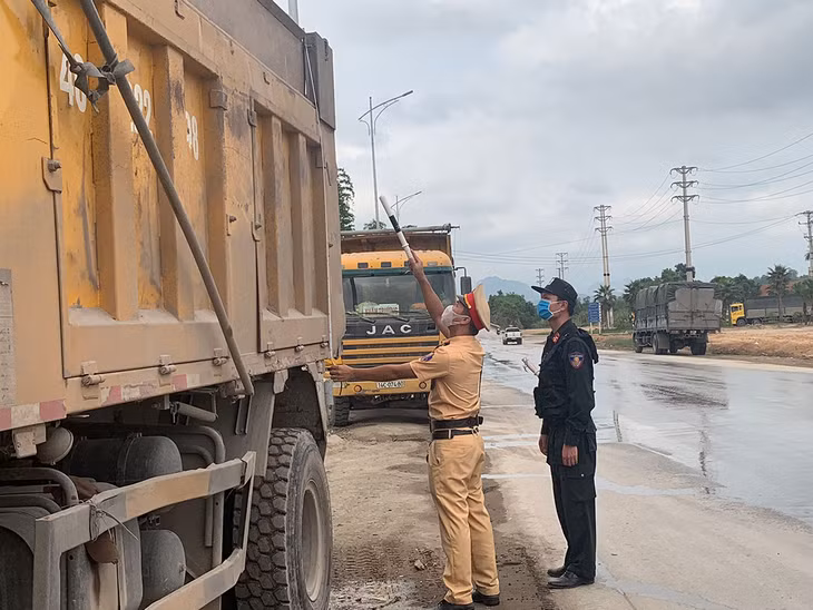 Cán bộ Đội CSGT số 2 Phòng CSGT đường bộ, đường sắt Công an tỉnh Quảng Ninh kiểm tra hành chính phương tiện lưu thông trên QL18