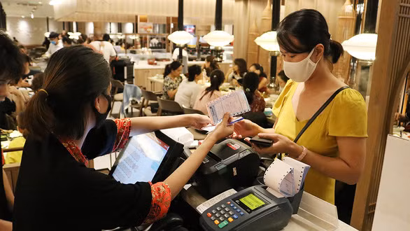 Khách hàng thanh toán bằng thẻ ngân hàng tại một nhà hàng trên đường An Dương Vương, Q.5, TP.HCM - Ảnh: NGỌC PHƯỢNG