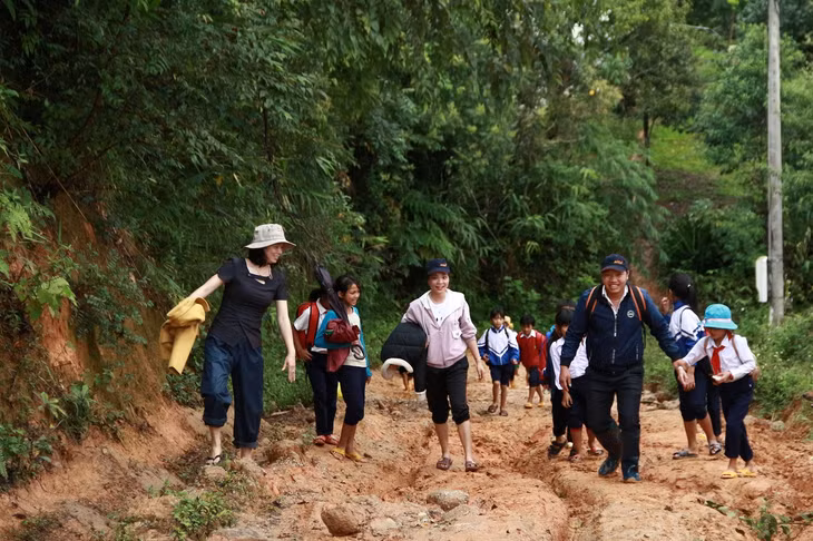Cô Hồ Thị ThùyVân (ngoài cùng bên trái), cùng đồng nghiệp vận động đưa học sinh đến lớp. Ảnh: Dung Nguyễn.