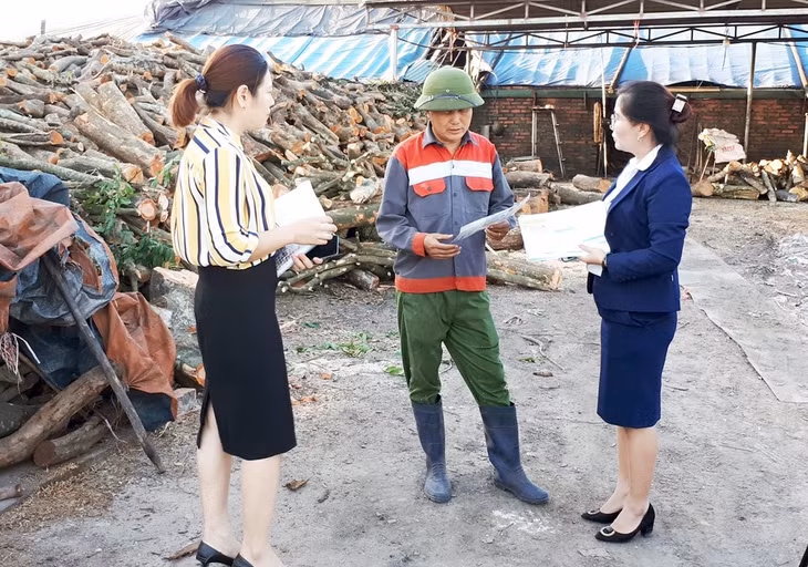 Cán bộ BHXH và Bưu điện TX Đông Triều tuyên truyền, vận động người dân tham gia BHXH tự nguyện tại xã Bình Khê (TX Đông Triều).