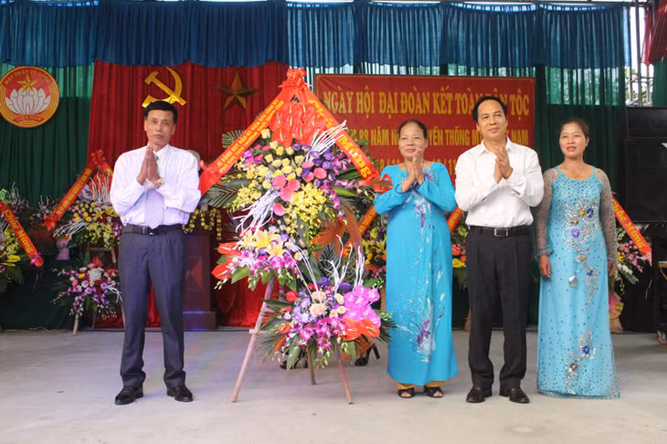 Đồng chí Đặng Huy Hậu, Phó Chủ tịch Thường trực UBND tỉnh tặng hoa chúc mừng cán bộ và nhân dân thôn Đạm Thủy.