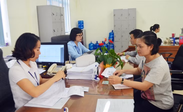 Cán bộ BHXH TP Cẩm Phả hướng dẫn người dân thực hiện chính sách BHXH, BHYT tại Trung tâm hành chính công thành phố.