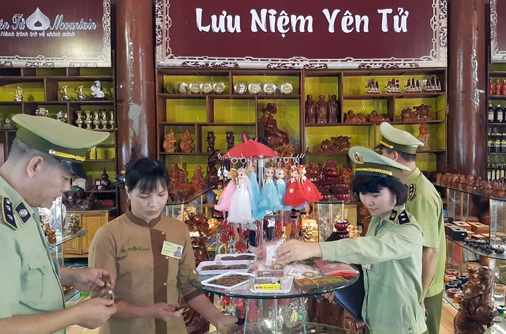 Cán bộ Đội QLTT số 6 tuyên truyền, kiểm tra, hướng dẫn hộ kinh doanh tại Khu di tích Yên Tử chấp hành nghiêm các quy định pháp luật trong hoạt động thương mại.