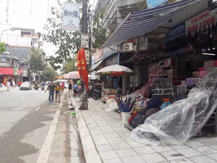 Người đi bộ ở TP Móng Cái phải đi xuống lòng đường do vỉa hè bị lấn chiếm làm nơi kinh doanh 