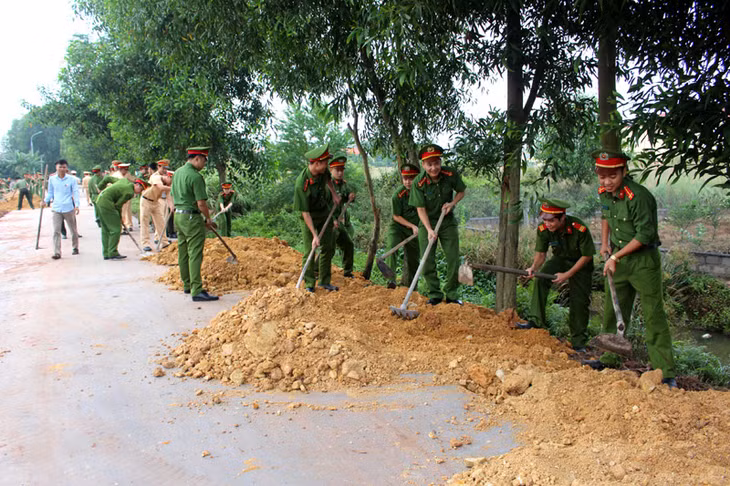 Cán bộ, chiến sĩ Công an TX Đông Triều ủng hộ ngày công, đổ đất mở rộng tuyến đường từ trụ sở UBND Việt Dân vào thôn Khê Thượng. 