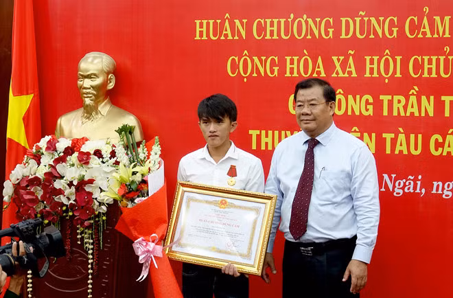 Phó chủ tịch UBND tỉnh Quảng Ngãi Nguyễn Tăng Bính trao Huân chương Dũng cảm cho ngư dân Trần Thanh Ron. Ảnh: Minh Hoàng.
