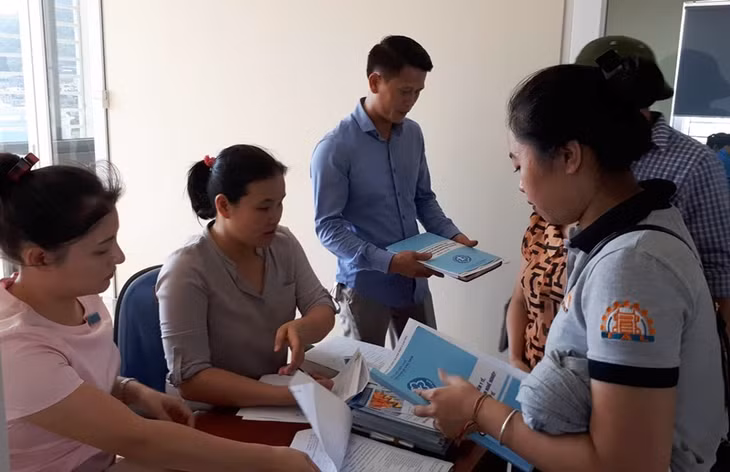 Cán bộ BHXH TP Cẩm Phả phát tài liệu tuyên truyền hướng dẫn cho đại diện doanh nghiệp tham gia tập huấn chính sách BHXH.