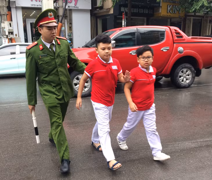Công an phường Hồng Gai đưa các cháu học sinh qua đường