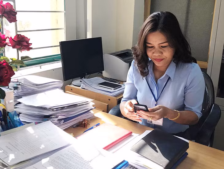 Bà Nguyễn Thị Hải, cán bộ công chức văn phòng thống kê được giao kiêm nhiệm công tác tiếp công dân đang báo cáo qua điện thoại với Chủ tịch UBND xã về việc phóng viên Báo Quảng Ninh đến liên hệ công tác.