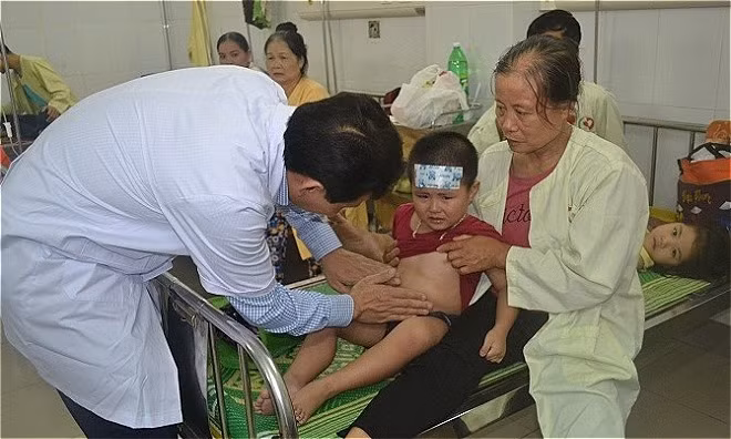 Bác sĩ đang kiểm tra cháu bé bị ngộ độc thực phẩm ở trường mầm non Xuân Nộn. Ảnh:. T.A.