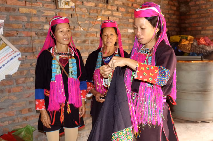 Chị em phụ nữ Dao chuẩn bị trang phục tới dự Ngày hội Đại đoàn kết dân tộc.