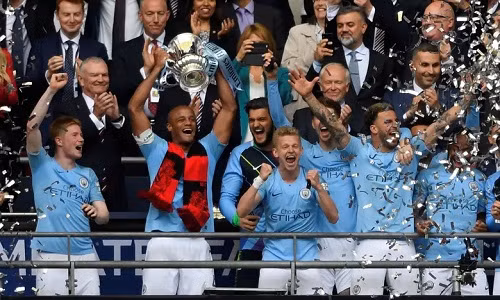 Kompany nâng chiếc Cup thứ ba của Man City ở mùa này. Ảnh: Reuters.