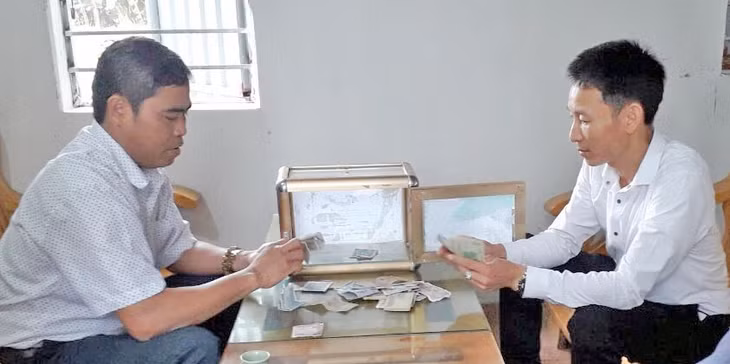 Anh Trung cùng cán bộ xã kiểm đếm số tiền đóng góp cho “Hòm quỹ thiện tâm”.