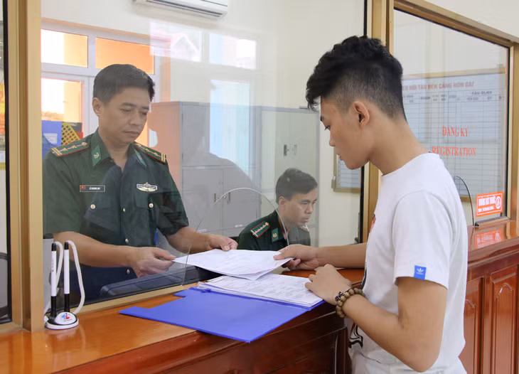 Cán bộ Đội Thủ tục, Đồn BP cửa khẩu cảng Hòn Gai hướng dẫn khách làm thủ tục xuất nhập khẩu. Ảnh: Nguyễn Dung