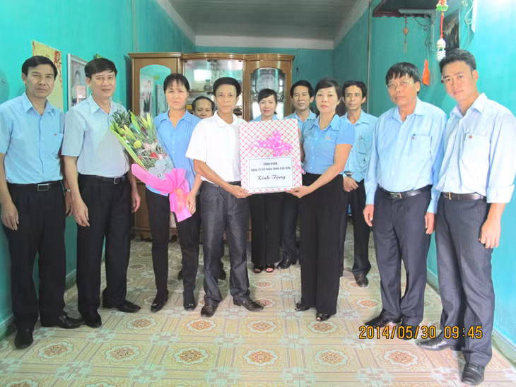 Lãnh đạo Công ty CP Than Cao Sơn trao quà trong lễ khánh thành nhà mới cho anh Dương Ngọc Ánh Sao (thứ 4 từ trái sang), phòng Bảo vệ Quân sự Công ty CP Than Cao Sơn