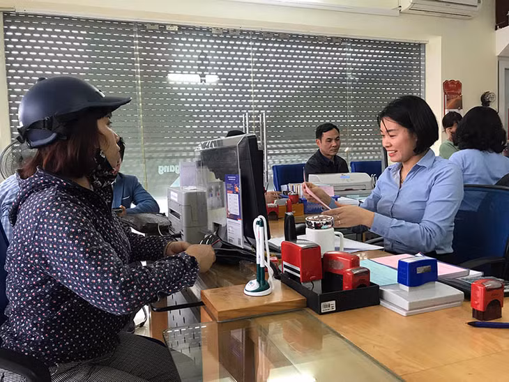 Nhân viên Ngân hàng BIDV chi nhánh Quảng Ninh, Phòng giao dịch Hồng Hà, TP Hạ Long, hướng dẫn người dân làm thủ tục thanh toán tiền điện, nước qua tài khoản tại ngân hàng.