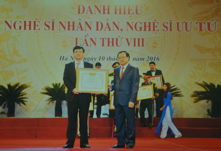 Ông Phạm Hữu Lượng (trái) đón nhận danh hiệu Nghệ sĩ Ưu tú. (Ảnh: Nhân vật cung cấp). 