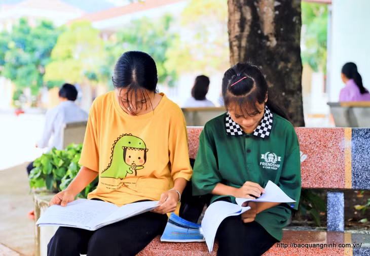 Đôi bạn dự thi tại Hội đồng thi THPT Bình Liêu tranh thủ ôn lại kiến thức trước khi vào phòng thi.