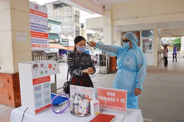  Đo thân nhiệt sàng lọc sức khỏe ngay tại cổng Bệnh viện Đa khoa tỉnh. (Ảnh chụp tháng 3/2020)