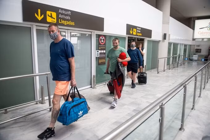 Du khách đến Lanzarote, thuộc quần đảo Canary. Giới chức nơi đây cho biết họ ban hành các biện pháp an toàn nghiêm ngặt và yêu cầu mọi người tuân thủ. Các khách sạn đều yêu cầu khách đeo mặt nạ ở nơi công cộng, giới hạn số người ngồi quanh bể bơi. Ảnh: AFP.