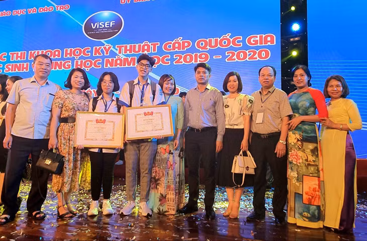 Em Hà My và Bá Toàn chụp ảnh lưu niệm cùng các thầy cô, gia đình sau khi giành giải nhì Cuộc thi KHKT dành cho học sinh trung học cấp quốc gia.