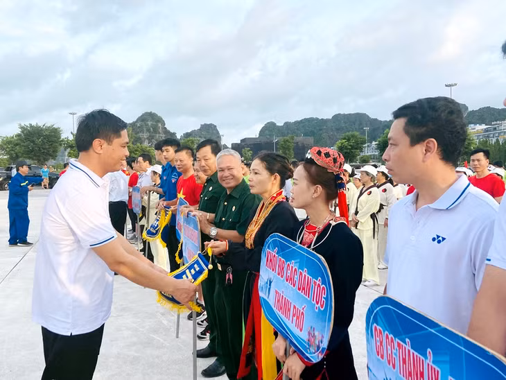 Lãnh đạo TP Hạ Long trao cờ lưu niệm cho các đơn vị tham gia.
