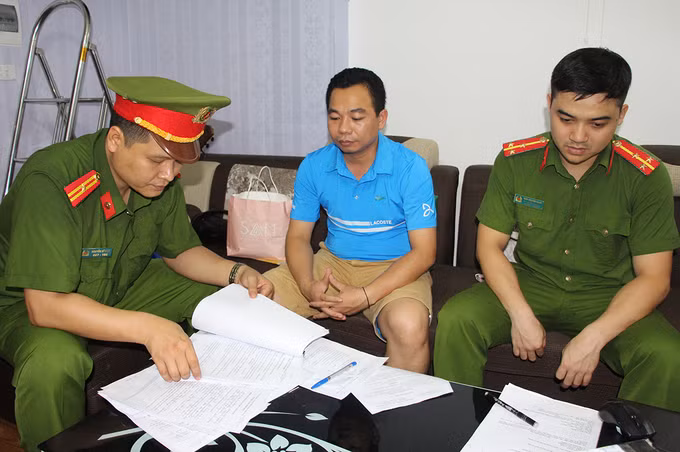 Bị can Bốn (ở giữa) lúc làm việc với công an. Ảnh công an cung cấp.