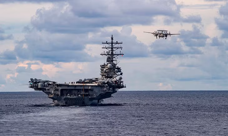 Tàu sân bay USS Nimitz (trái) và máy bay cảnh báo sớm Northrop Grumman E-2 Hawkeye diễn tập trên Biển Đông, ngày 7/6. Ảnh: US Navy.