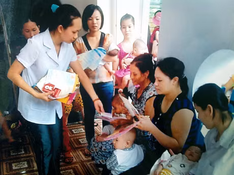 Cán bộ dân số phường Cẩm Thạch (TX Cẩm Phả) tư vấn, phát tờ rơi tuyên truyền kiến thức KHHGĐ cho phụ nữ trong độ tuổi sinh đẻ trên địa bàn.