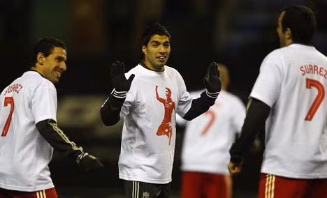 Suarez (giữa) và các đồng đội mặc áo ủng hộ anh trước trận đấu tối qua.