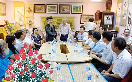 Nhà thư pháp Vũ Ngọc Kỳ (bên phải) và ông Nguyễn Ngọc Đàm (bên trái) trò chuyện với các hội viên trong lễ ra mắt CLB Thư hoạ Hạ Long.