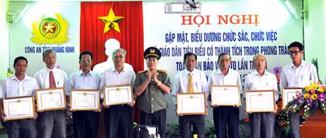 Đồng chí Nguyễn Bá Bính, Phó Giám đốc Công an tỉnh tặng giấy khen của Công an tinh cho các chức sắc, chức việc và giáo dân Công giáo đạt thành tích xuất sắc trong phong trào toàn dân bảo vệ ANTQ trong 2 năm 2012-2013.