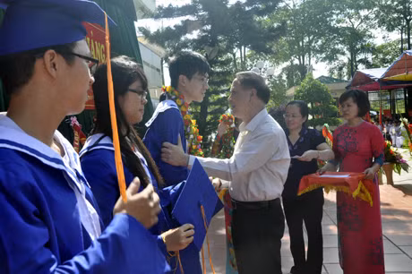Đồng chí Đỗ Thông, Phó Chủ tịch Thường trực UBND tỉnh trao vòng hoa, quà chúc mừng các em học sinh đỗ đại học của nhà trường tại lễ khai giảng