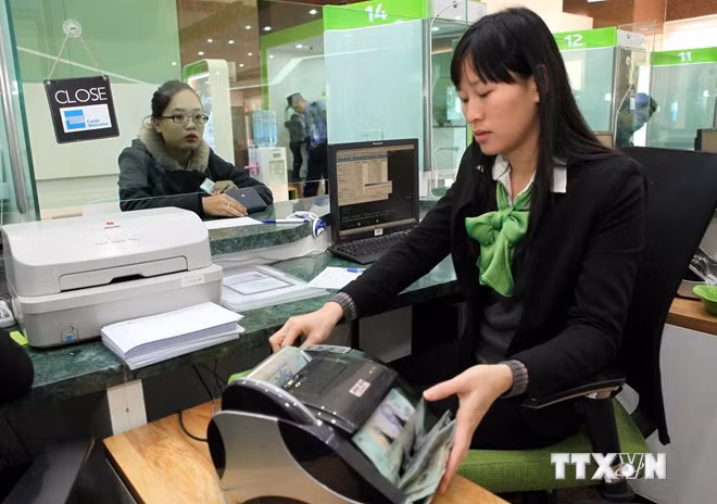  Giao dịch thanh toán với khách hàng tại Hội sở Vietcombank (Hà Nội). (Ảnh: Trần Việt/TTXVN)