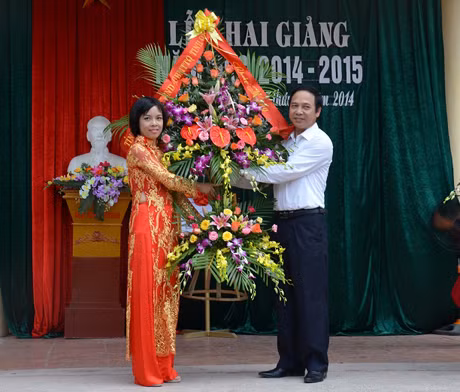 Đồng chí Đặng Huy Hậu, Phó Chủ tịch UBND tỉnh tặng hoa chúc mừng nhà trường trong năm học mới.