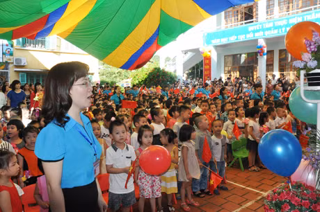 Cô và bé chào cờ đón năm học mới.