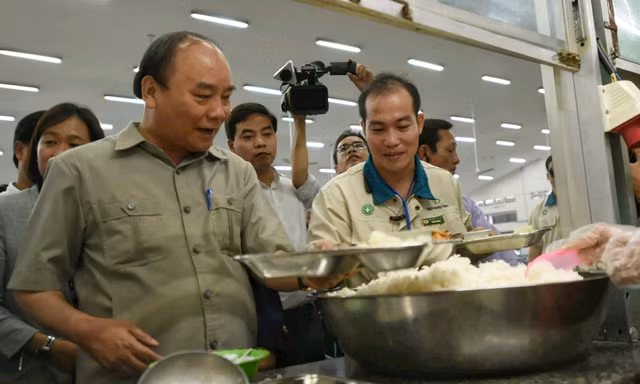 Thủ tướng cùng các công nhân lấy suất cơm ca chiều. - Ảnh: VGP/Quang Hiếu