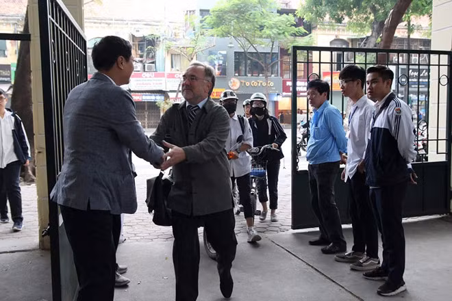 Thầy Quốc Bình bắt tay giáo viên, vẫy tay chào học sinh mỗi sáng, chiều. Ảnh: Đ.T.