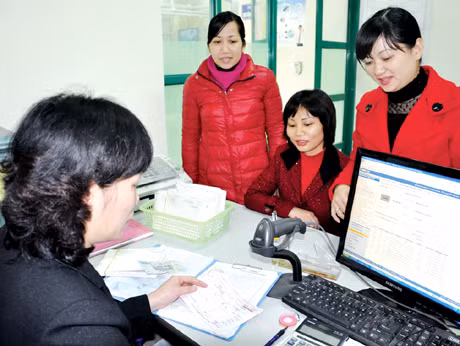 Nhân viên Công ty Điện lực Hạ Long thu tiền điện của khách hàng tại điểm thu phường Hồng Hải.