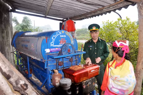 Cán bộ Đồn Biên phòng Bắc Sơn hướng dẫn người dân xã Hải Sơn (TP Móng Cái) sử dụng máy xay xát lúa.