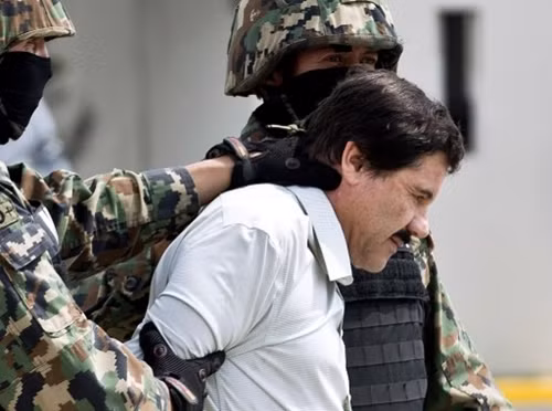 Hai lính thủy quân lục chiến áp giải trùm ma túy Guzman. Ảnh: AFP.