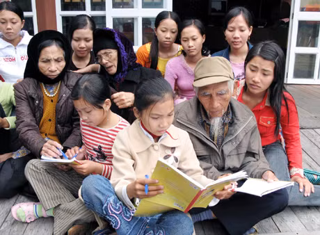 Ông Nguyễn Văn Hưu trong một buổi dạy hát giao duyên cho thiếu niên làng chài Cửa Vạn. Ảnh: Đại Dương