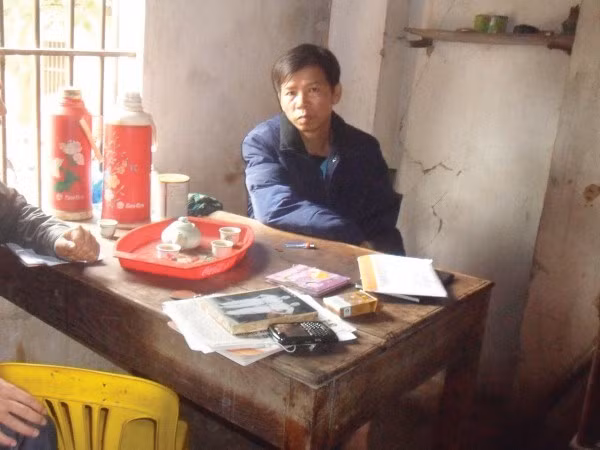 Ông Chấn đang trình bày với phóng viên trong ngôi nhà ọp ẹp đang đứng trước nguy cơ bị mất vì khoản nợ lớn của gia đình.