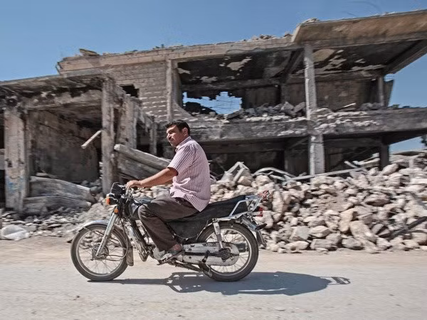 Một người dân đi qua những tòa nhà bị phá hủy trong các thị trấn Kobani của Syria vào tháng trước. (Nguồn: theguardian.com)