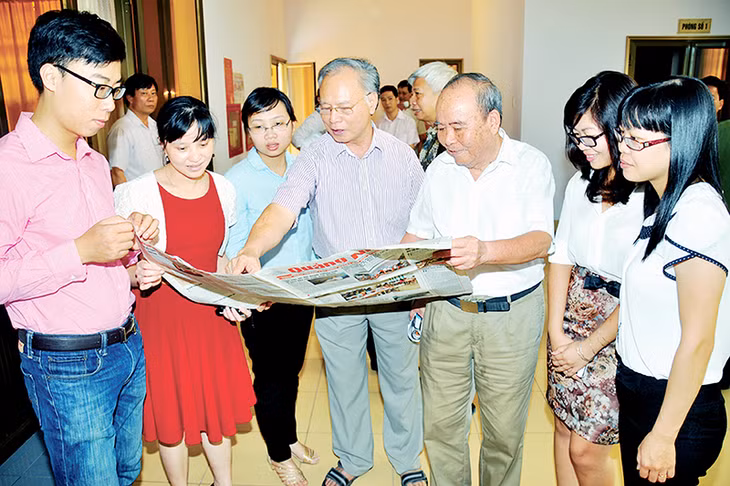 Các nhà báo lão thành Nguyễn Huy Trợ, Vũ Điều trao đổi nghiệp vụ với phóng viên trẻ Báo Quảng Ninh. Ảnh: Đỗ Phương