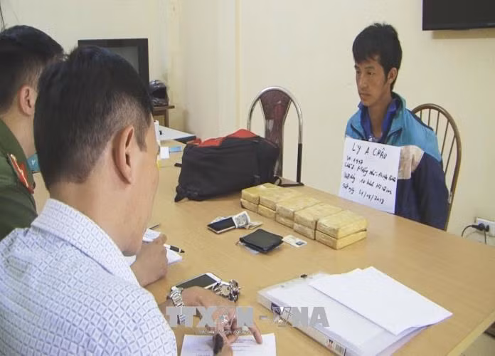 Đối tượng Ly A Châu cùng tang vật bị thu giữ tại cơ quan điều tra. Ảnh: Xuân Tư/TTXVN