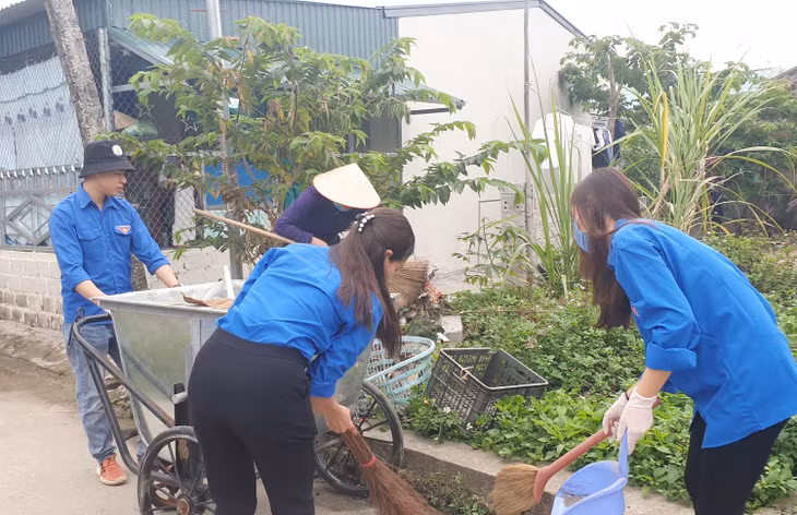 Đồng chí Lê Hoàng Sơn (đẩy xe rác) cùng với các đoàn viên trong thôn dọn dẹp vệ sinh môi trường đường làng, ngõ xóm.