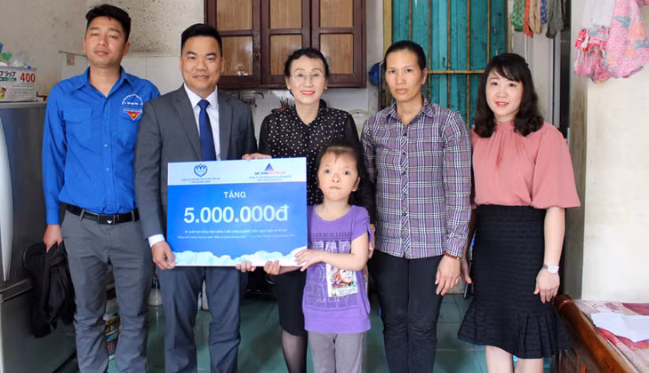Bà Nguyễn Thị Luận (giữa) trong dịp cùng đại diện Công ty CP Dịch vụ và địa ốc Đất Xanh Duyên Hải trao học bổng cho em Lê Trà My.