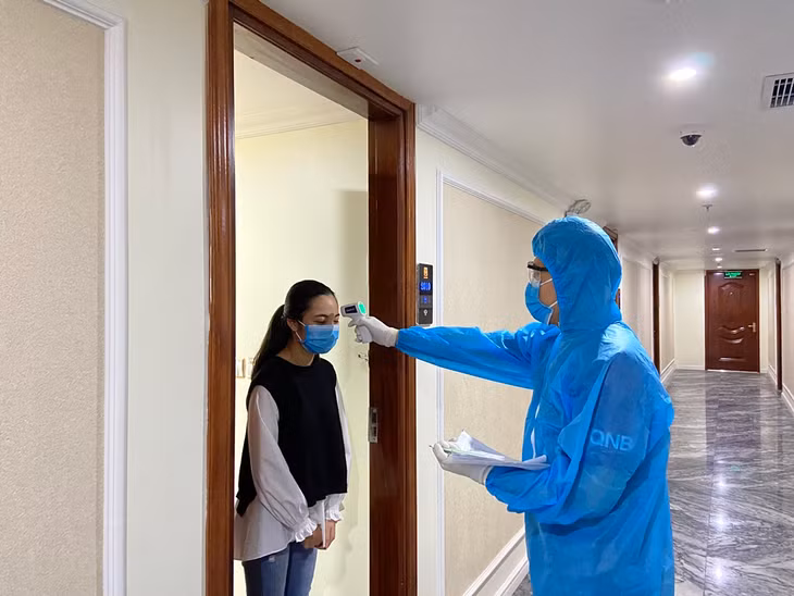 Cán bộ y tế của TP Hạ Long tiến hành kiểm tra thân nhiệt cho khách cách ly y tế tại khách sạn Thái Sơn.