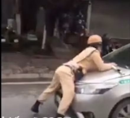 Trung uý Vũ Hoàng Xuân bị lái xe hất lên nắp capo.